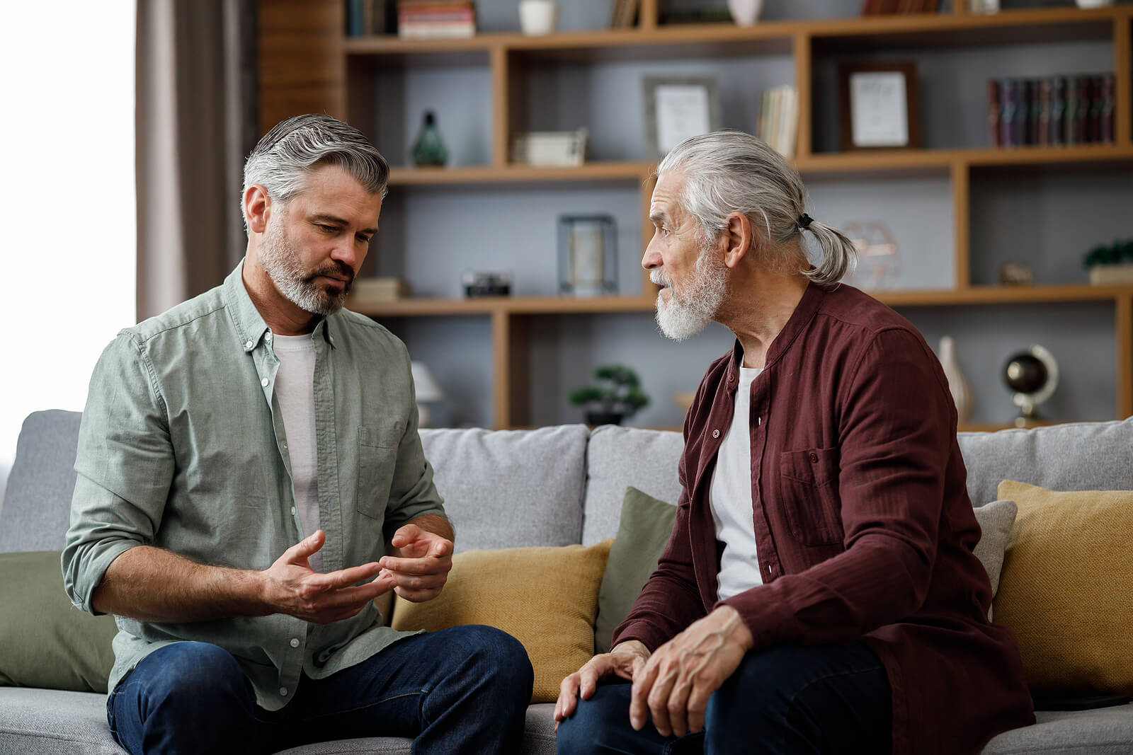 Older father and son talking on a couch