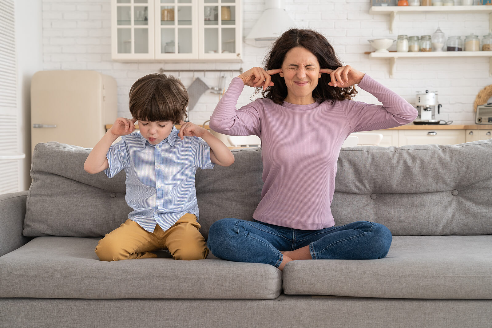 Mom and son frowning plugging ears with fingers
