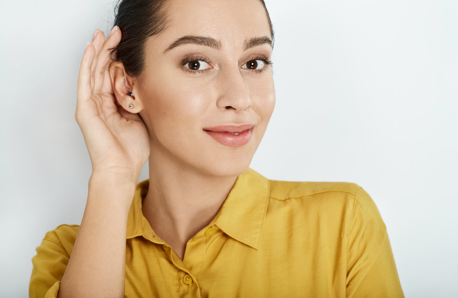 Young woman cupping her hand around her ear