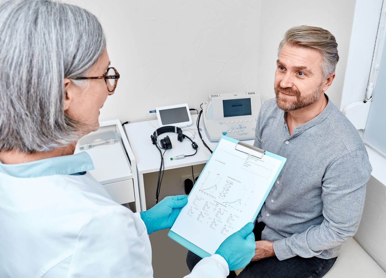 Man receiving hearing test results from Audiologist